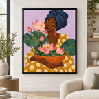 Woman with pink lotus flowers canvas wall art in a black frame above a cream armchair
